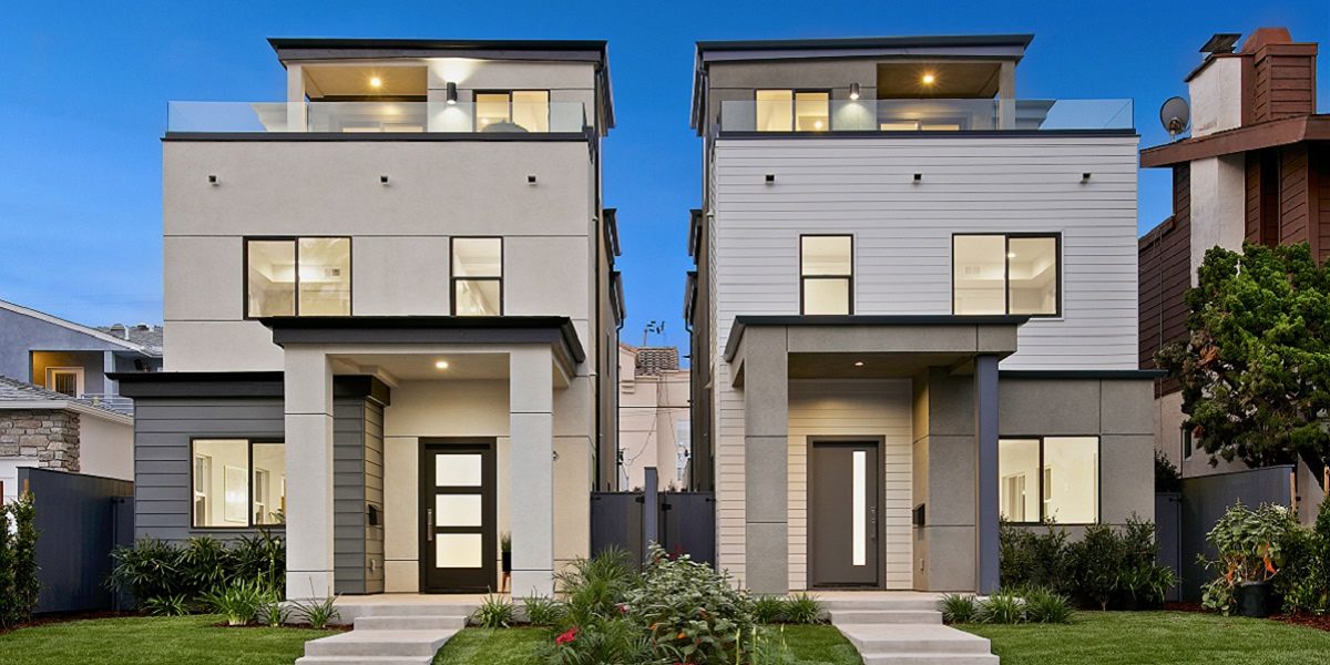 Two houses with a front lawn and a building